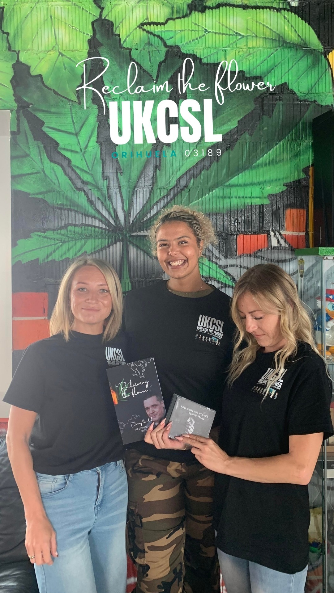 Three women sharing the Reclaim the Flower book at The Unit CSC